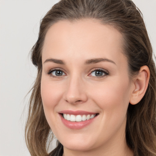 Joyful white young-adult female with long  brown hair and grey eyes