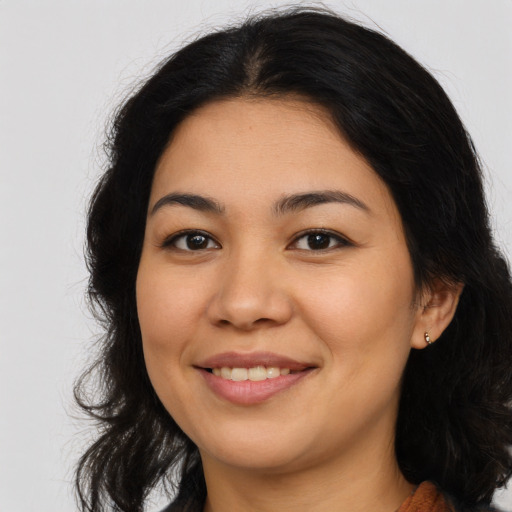 Joyful latino young-adult female with long  brown hair and brown eyes