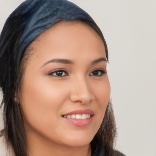 Joyful latino young-adult female with long  brown hair and brown eyes