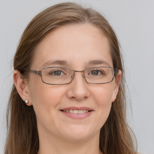 Joyful white adult female with long  brown hair and grey eyes