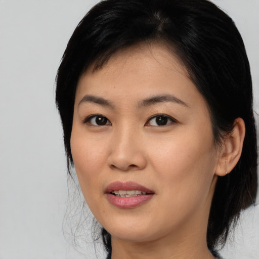 Joyful asian young-adult female with medium  black hair and brown eyes
