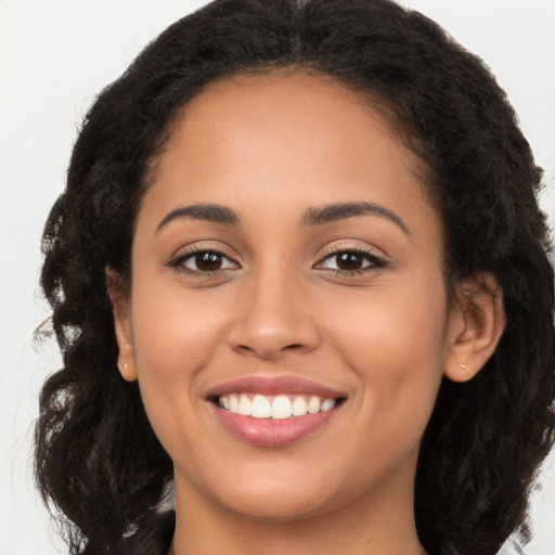 Joyful latino young-adult female with long  brown hair and brown eyes