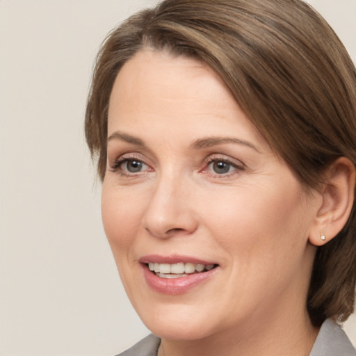 Joyful white adult female with medium  brown hair and brown eyes