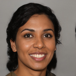 Joyful latino young-adult female with medium  black hair and brown eyes