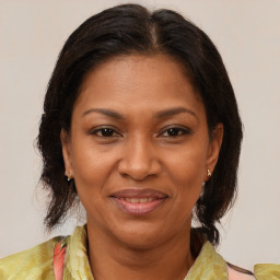 Joyful black adult female with medium  brown hair and brown eyes