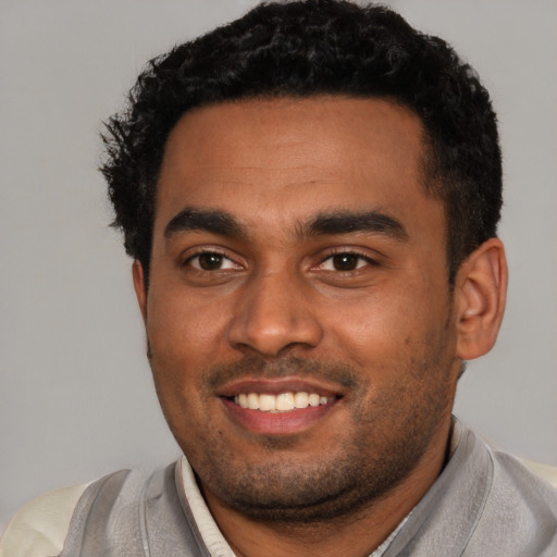Joyful black young-adult male with short  black hair and brown eyes