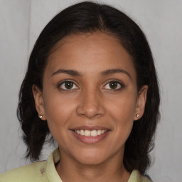 Joyful latino young-adult female with medium  brown hair and brown eyes