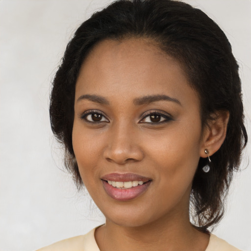 Joyful black young-adult female with long  brown hair and brown eyes
