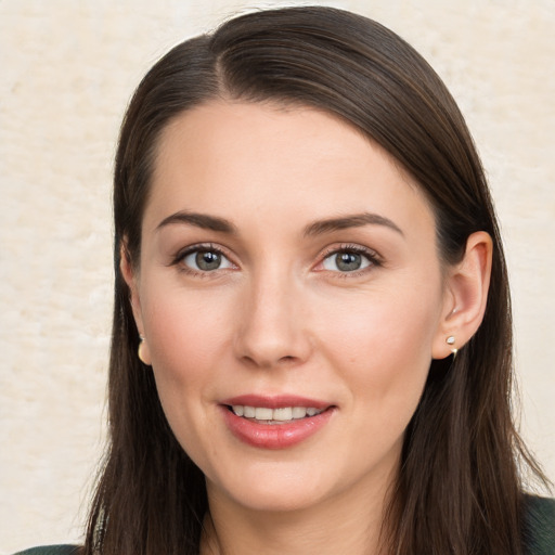 Joyful white young-adult female with long  brown hair and brown eyes