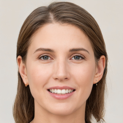 Joyful white young-adult female with long  brown hair and grey eyes