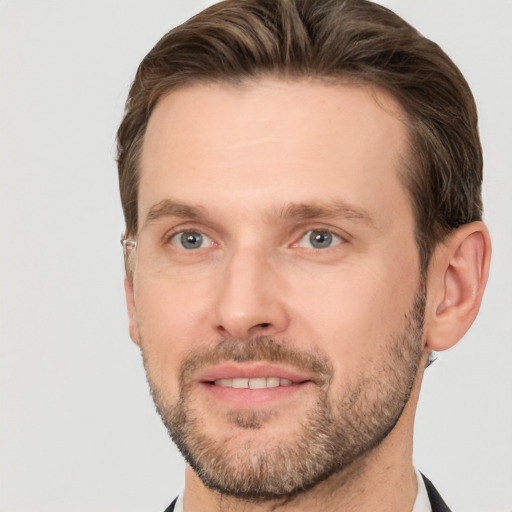 Joyful white adult male with short  brown hair and grey eyes