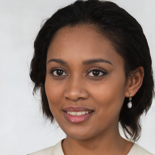 Joyful black young-adult female with medium  black hair and brown eyes