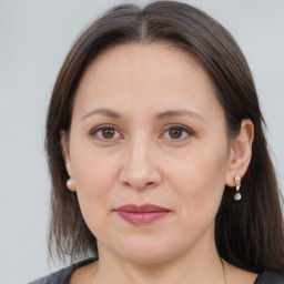 Joyful white adult female with long  brown hair and brown eyes