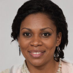 Joyful black adult female with medium  brown hair and brown eyes