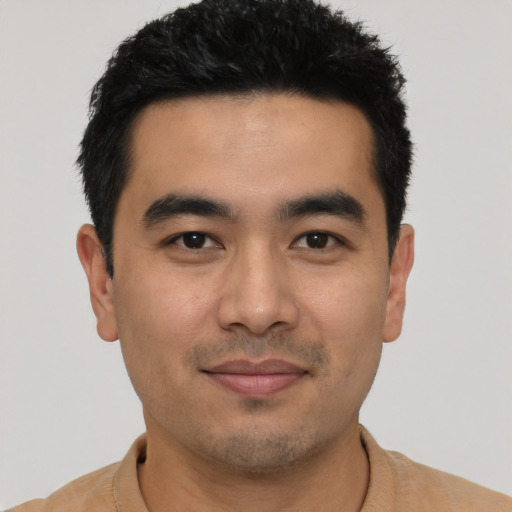Joyful asian young-adult male with short  black hair and brown eyes