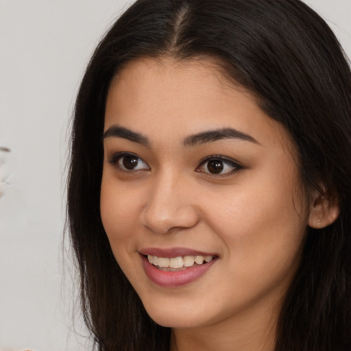 Joyful asian young-adult female with long  brown hair and brown eyes