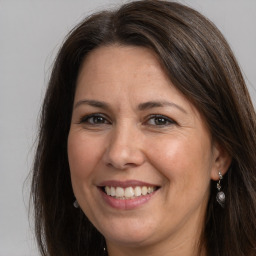 Joyful white adult female with long  brown hair and brown eyes