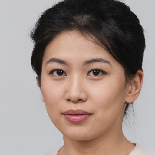 Joyful asian young-adult female with short  brown hair and brown eyes
