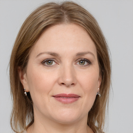 Joyful white adult female with medium  brown hair and grey eyes