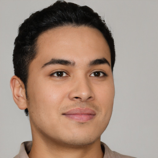 Joyful latino young-adult male with short  brown hair and brown eyes