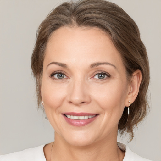 Joyful white adult female with medium  brown hair and brown eyes