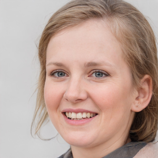 Joyful white young-adult female with medium  brown hair and blue eyes