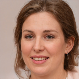 Joyful white adult female with medium  brown hair and grey eyes