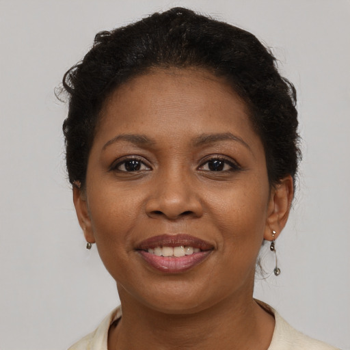 Joyful black young-adult female with short  brown hair and brown eyes