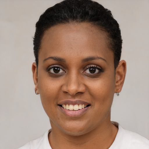 Joyful black young-adult female with short  black hair and brown eyes