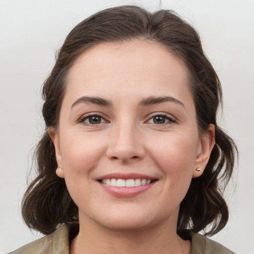 Joyful white young-adult female with medium  brown hair and grey eyes