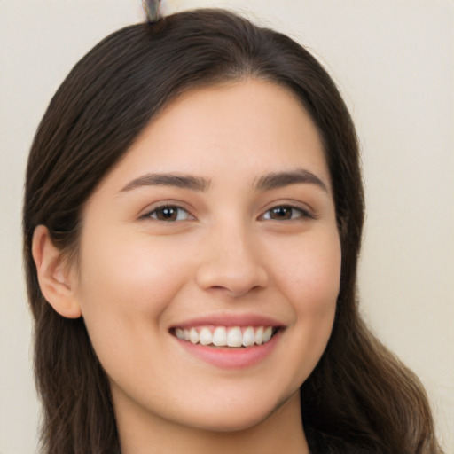 Joyful white young-adult female with long  brown hair and brown eyes