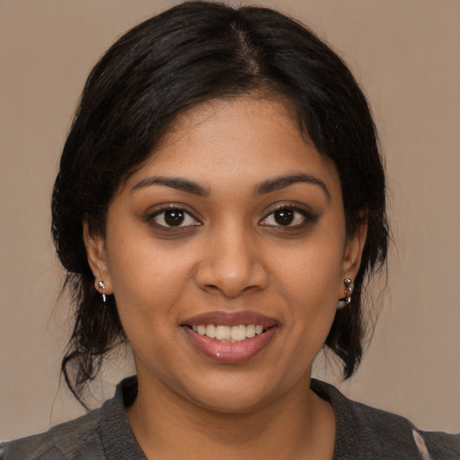 Joyful black young-adult female with medium  brown hair and brown eyes