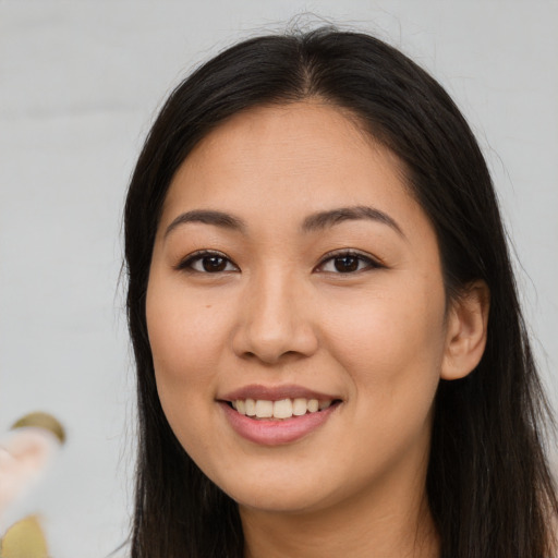 Joyful asian young-adult female with long  brown hair and brown eyes