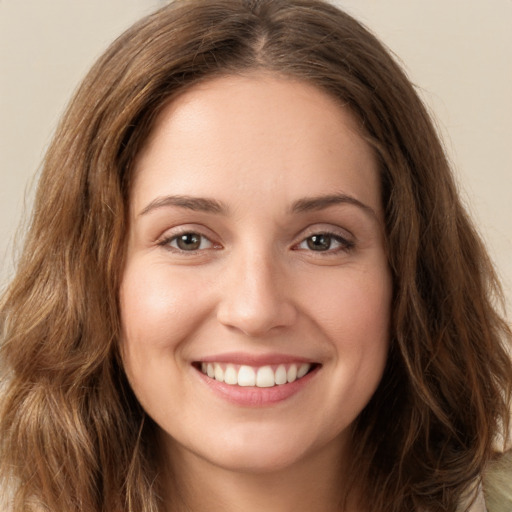 Joyful white young-adult female with long  brown hair and green eyes