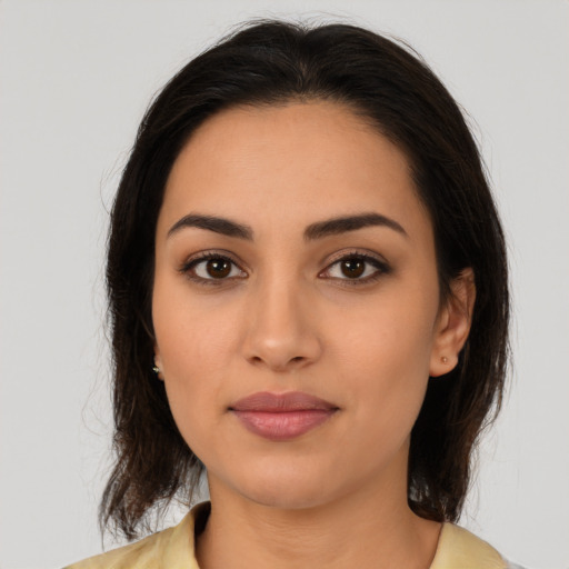 Joyful latino young-adult female with medium  brown hair and brown eyes