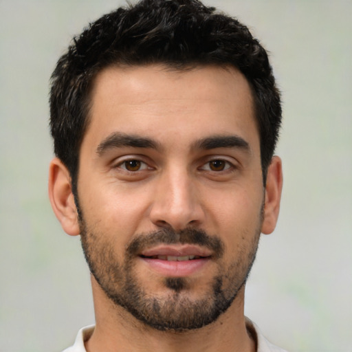 Joyful latino young-adult male with short  black hair and brown eyes