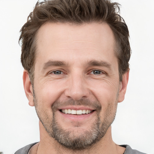 Joyful white adult male with short  brown hair and grey eyes