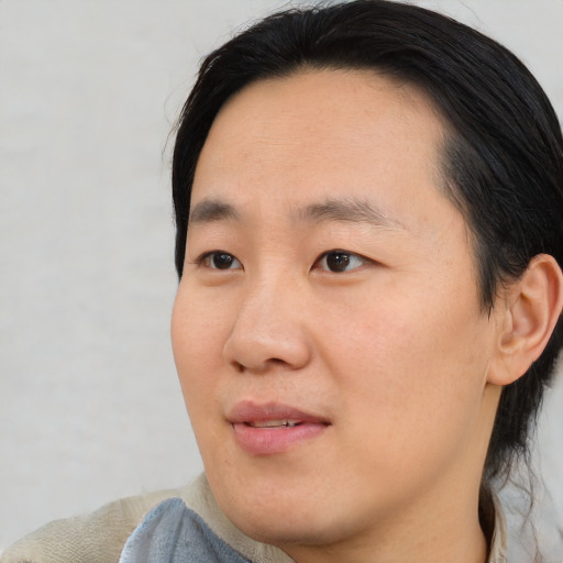 Joyful asian young-adult male with short  brown hair and brown eyes