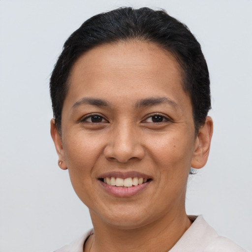 Joyful latino adult female with short  brown hair and brown eyes