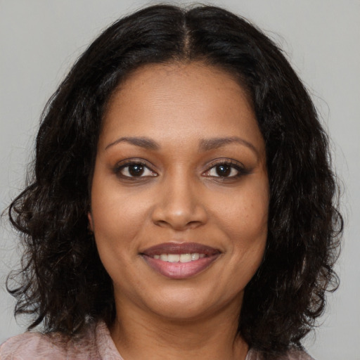 Joyful black young-adult female with medium  brown hair and brown eyes