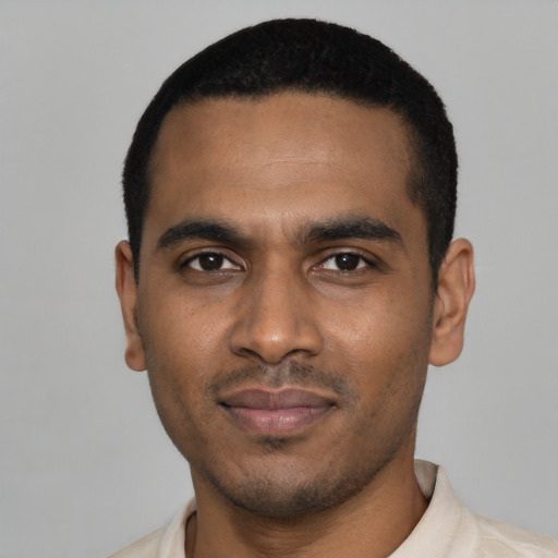 Joyful black young-adult male with short  black hair and brown eyes