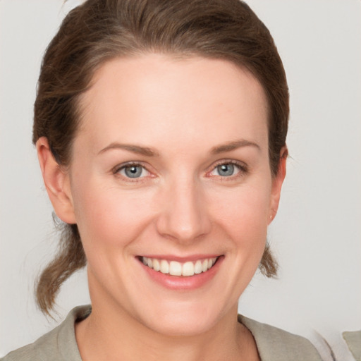 Joyful white young-adult female with short  brown hair and grey eyes