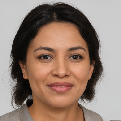 Joyful latino young-adult female with medium  brown hair and brown eyes