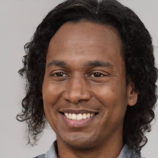 Joyful black young-adult male with short  brown hair and brown eyes