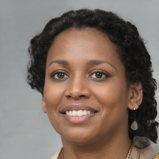 Joyful black young-adult female with short  brown hair and brown eyes