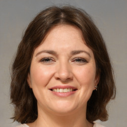 Joyful white adult female with medium  brown hair and brown eyes