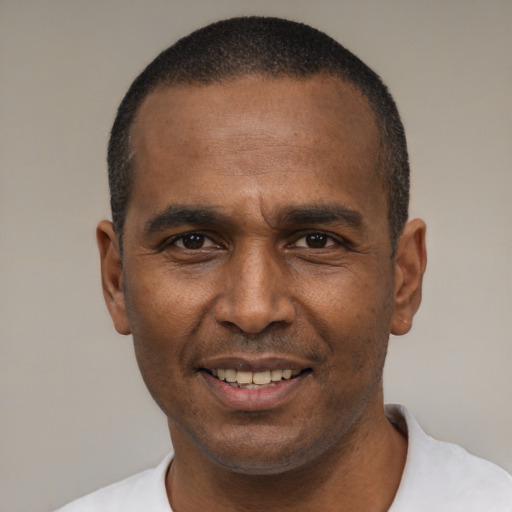 Joyful black adult male with short  black hair and brown eyes