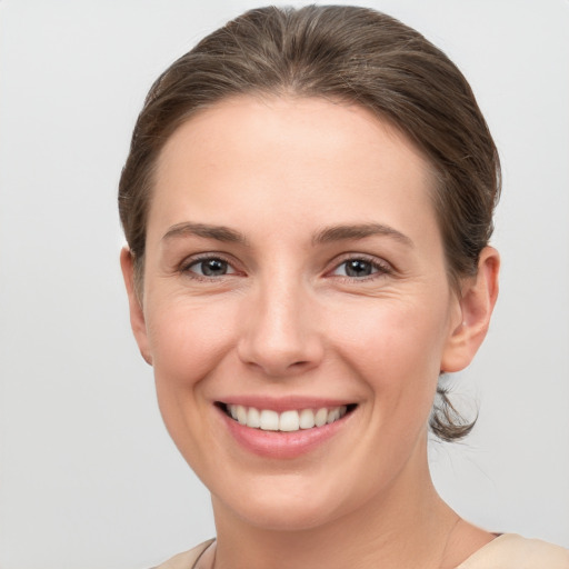 Joyful white young-adult female with short  brown hair and grey eyes