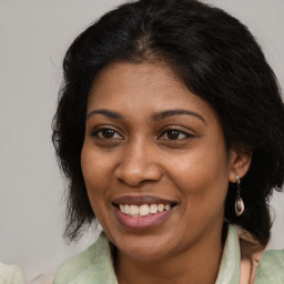 Joyful black young-adult female with long  brown hair and brown eyes