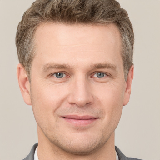 Joyful white adult male with short  brown hair and grey eyes